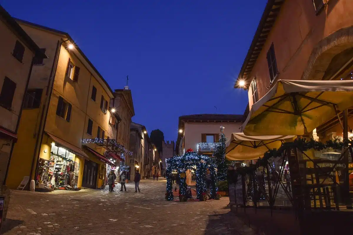 Main street of the walled village of Gradara with shops and cafes at dusk