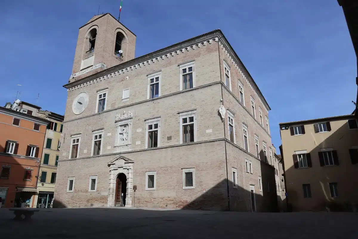 Stone facade and bell tower of Palazzo della Signoria on Piazza Colocci in Jesi