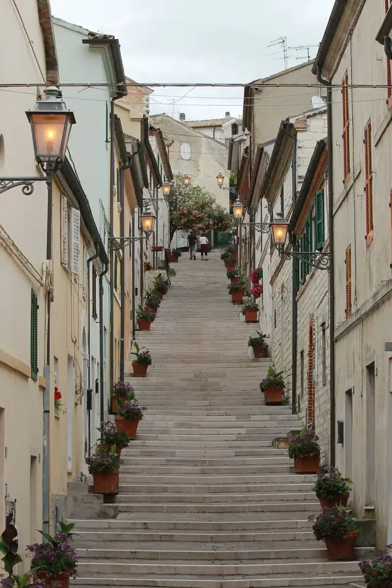 The Costarella stone staircase in Numana old town lined with houses and flower pots